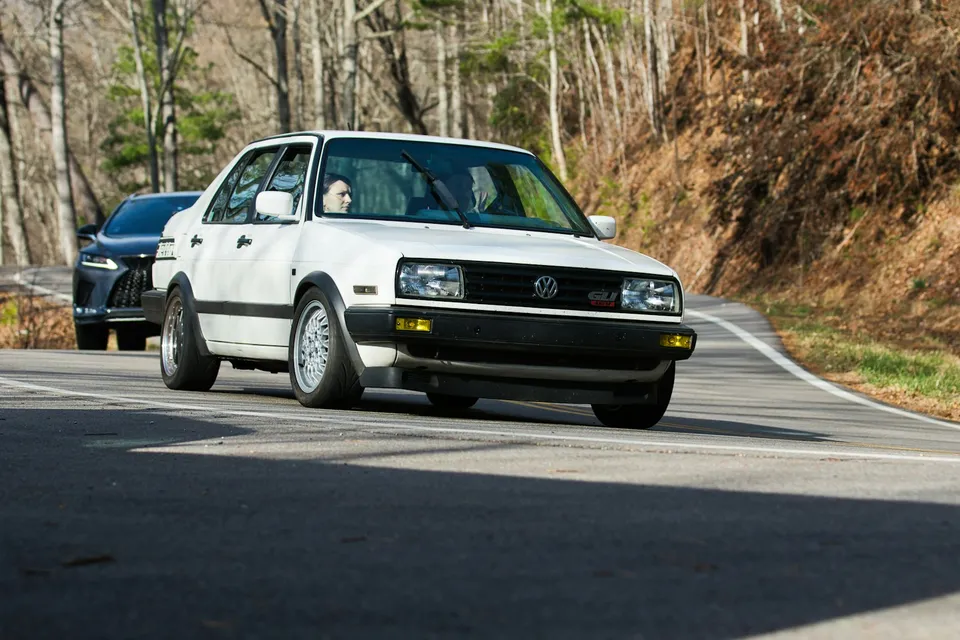 A white Volkswagen on a winding road — illustrative photograph